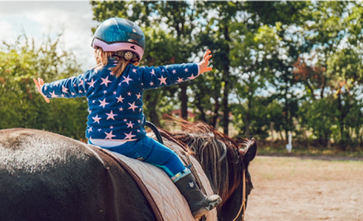 girl on horseback wearing helmet